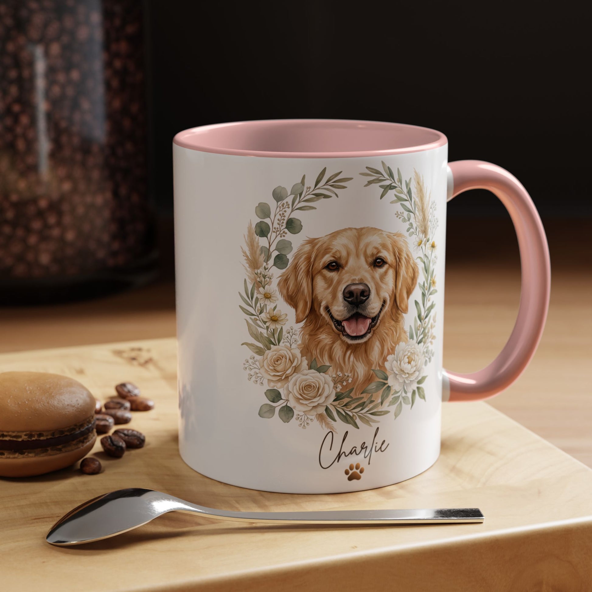 Mug with a dog illustration and floral design on a wooden surface with coffee beans and a macaron.