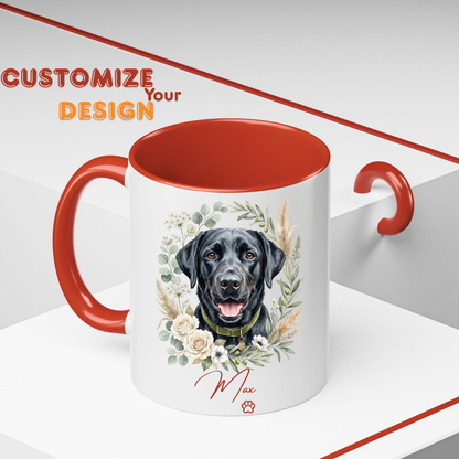 A white ceramic mug with a red interior and handle, featuring a custom illustration of a black Labrador retriever surrounded by flowers and the name 'Max' printed below. The background is a clean white studio setting with a red handle on the right side and a 'CUSTOMIZE Your DESIGN' banner overlay in the top left.