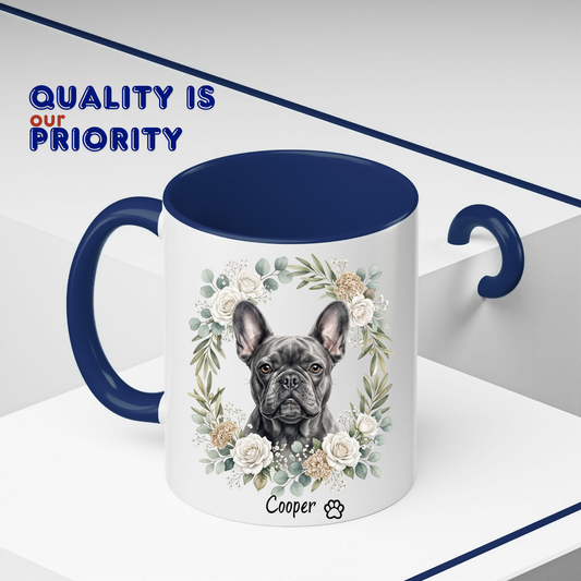 A white ceramic mug with a dark blue handle and interior, featuring a printed illustration of a French bulldog surrounded by white and beige flowers. The name 'Cooper' and a paw print are printed below the illustration.